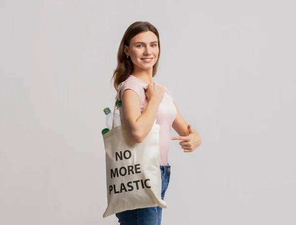 美しいミレニアル女性運ぶエコトートバッグでこれ以上のプラスチック製の碑文 — ストック写真