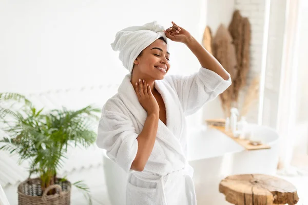 Gelukkig Afrikaans amerikaans vrouw dansen dragen witte badjas in badkamer — Stockfoto