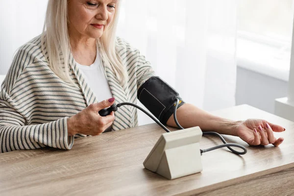 Signora anziana che misura la pressione sanguigna a casa — Foto Stock