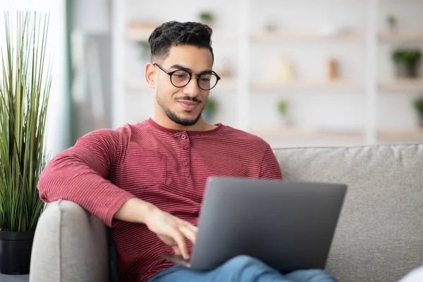 Närbild av arabiska killen med glasögon med laptop hemma — Stockfoto