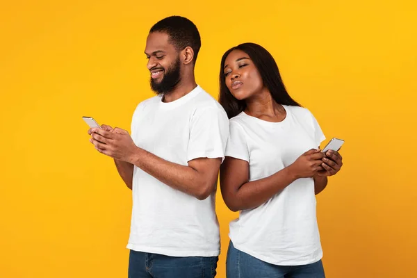 Negro mujer chequeando su novio teléfono móvil — Foto de Stock