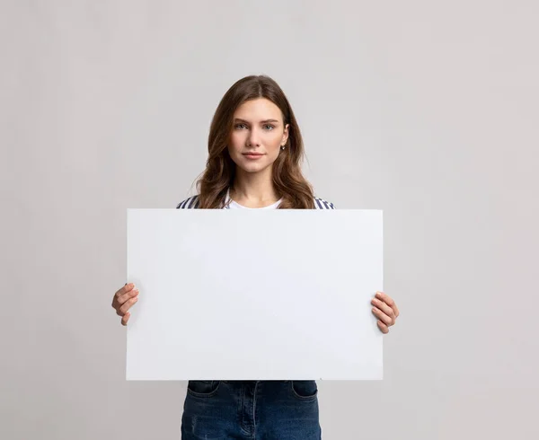 Platz für Ihre Anzeige. Schöne junge Frau mit leerem Plakat — Stockfoto