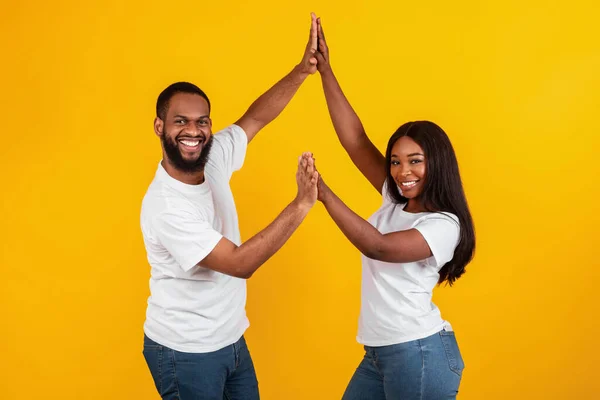 Retrato de casal negro feliz celebrando vitória dando alta cinco — Fotografia de Stock