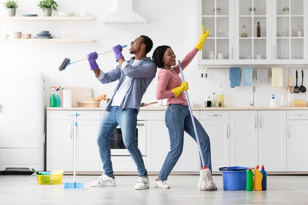 Vreugdevol Afrikaans amerikaans gezin hebben plezier tijdens het schoonmaken keuken — Stockfoto