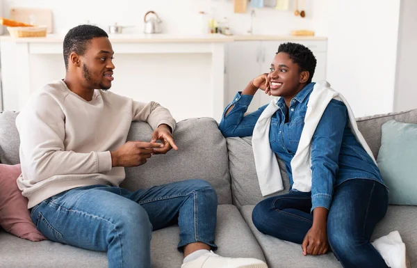 Pareja negra hablando y pasando tiempo juntos descansando en el sofá —  Fotos de Stock