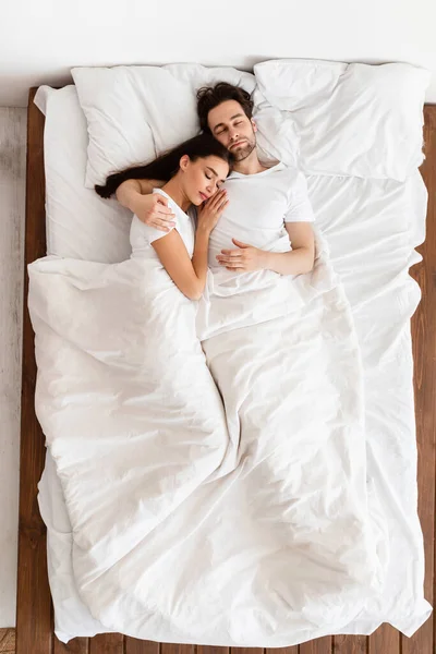 Pareja abrazándose durmiendo juntos acostados en el dormitorio, Vista superior, Vertical — Foto de Stock