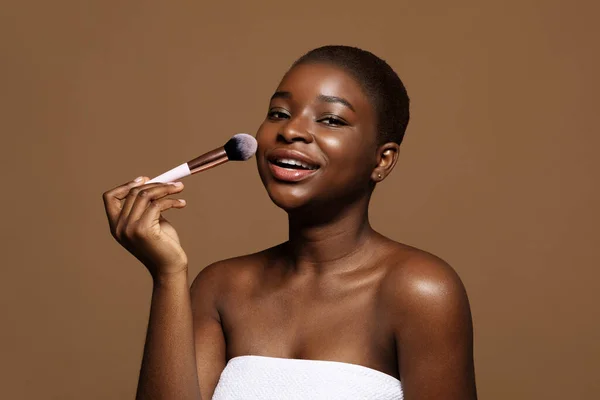 Daglig makeup. Söt svart dam med ren hud håller upp borste — Stockfoto