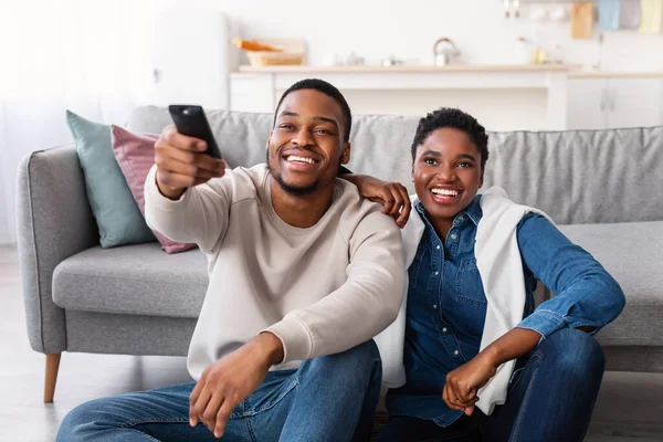 Usmívající se afro pár tráví víkend spolu sledování televize — Stock fotografie