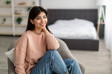 Gülümseyen genç kadın hafta sonu evde dinleniyor.