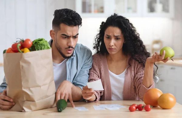 Shocking Prices. Confused Middle Eastern Spouses Checking Bills After Grocery Shopping — Stock Photo, Image