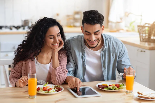 Mladý pár ze Středního východu nakupování on-line na digitální tabletu při snídani — Stock fotografie