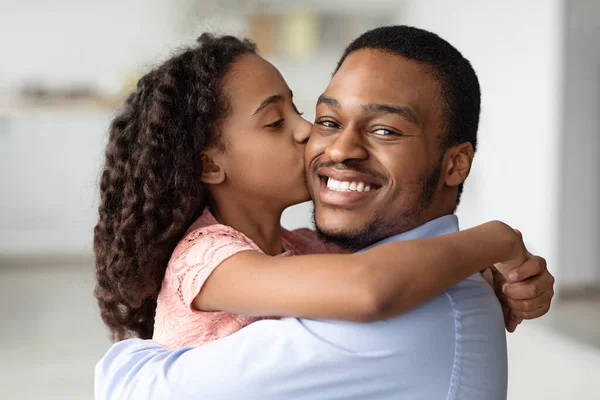 Menina negra bonito beijando seu pai sorridente, close-up — Fotografia de Stock