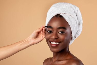 Makyöz Afrika kökenli Amerikalı bir kadına maskara sürüyor.