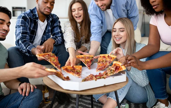 Gelukkige multiraciale vrienden chatten, pizza eten samen, hebben een klein feestje thuis — Stockfoto