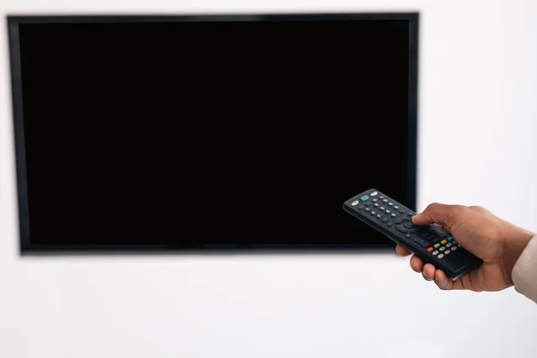 Chico negro viendo la televisión y usando mando a distancia — Foto de Stock