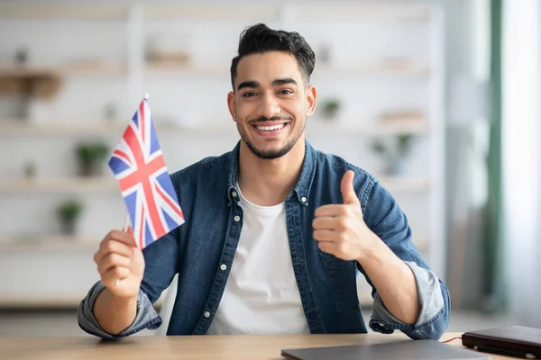 Usmívající se chlap s vlajkou Velké Británie ukazující palec nahoru — Stock fotografie