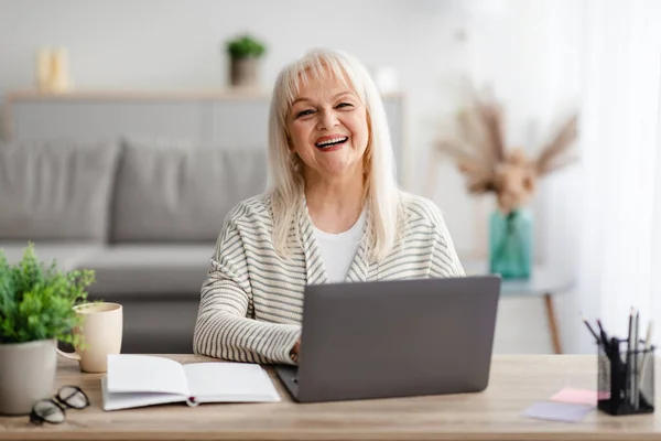 Volwassen vrouw zitten aan het bureau en werken op de computer — Stockfoto