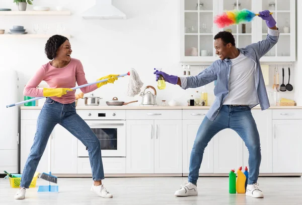 Engraçado amantes afro-americanos lutando com ferramentas de limpeza — Fotografia de Stock