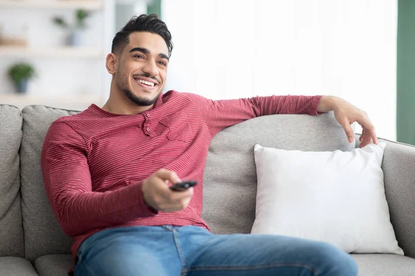 Relajado chico de Oriente Medio cambiando canales en la televisión — Foto de Stock