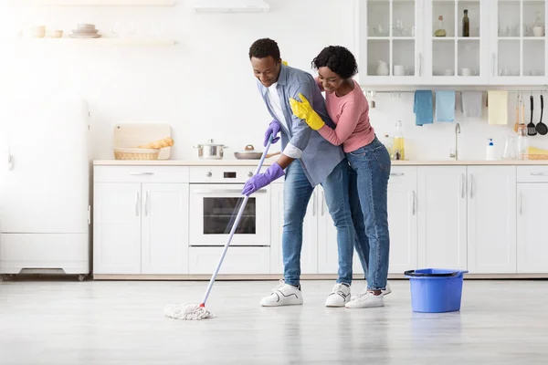 美丽的非洲裔美国夫妇在厨房扫地 — 图库照片
