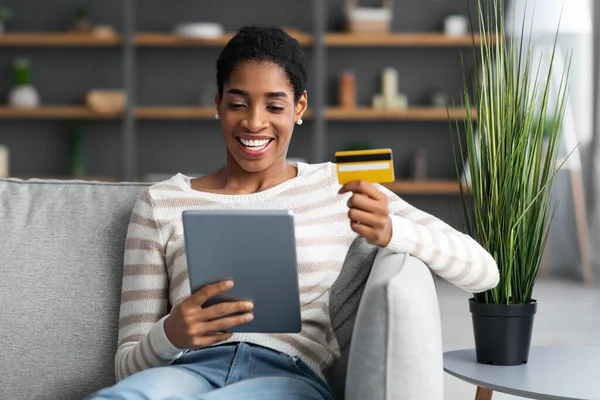 Shopping online. Donna afroamericana allegra che utilizza tablet digitale e carta di credito — Foto Stock