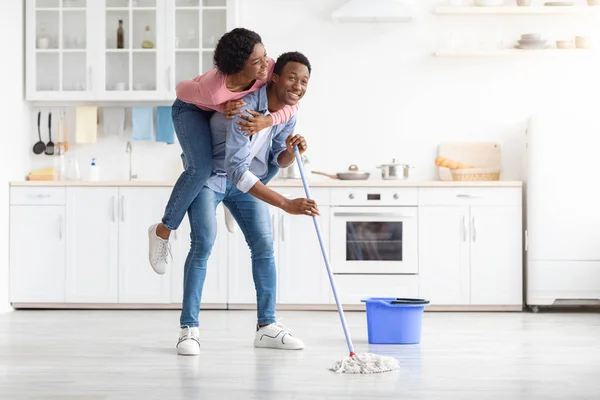 Schattig zwart paar having plezier terwijl dweilen keuken — Stockfoto