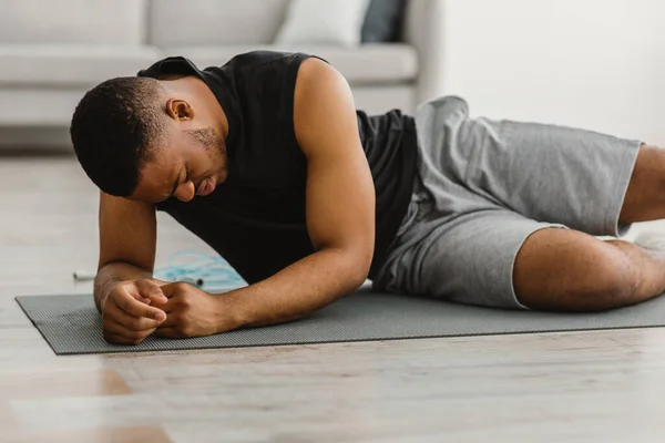 Homem de fitness preto se sentindo mal durante o exercício em casa — Fotografia de Stock