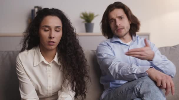 Kamerayla konuşan genç evli bir çift, danışmana sorunlarını anlatan bir kadın, kanepede oturan hoşnutsuz bir adam. — Stok video