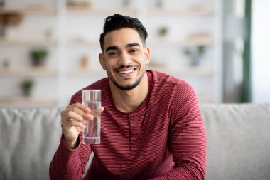 Mutlu Arap adam evde su içiyor.