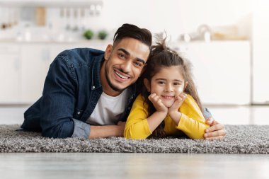 Babanla vakit geçir. Küçük kız ve Arap babası evde poz veriyorlar.