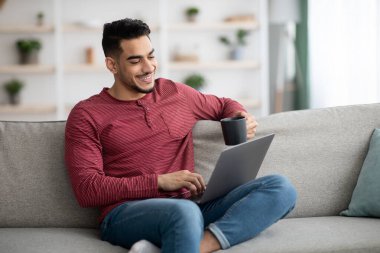 Gülümseyen Arap adam internette bayanlarla sohbet ediyor.