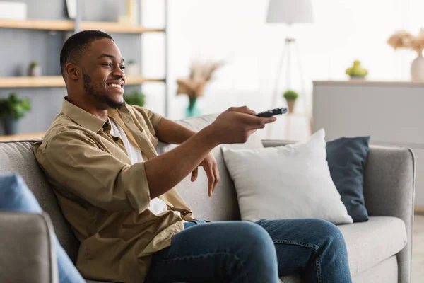 Happy African American Man βλέποντας τηλεόραση αλλαγή καναλιών στο σπίτι — Φωτογραφία Αρχείου