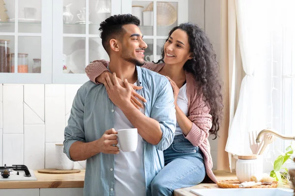 Romantiska arabiska par omfamna i köket medan du dricker morgonkaffe tillsammans — Stockfoto
