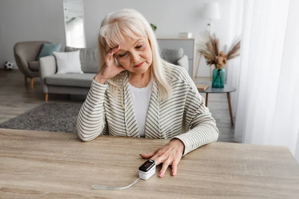 Senior mulher usando oxímetro em casa. Conceito de cuidados de saúde — Fotografia de Stock