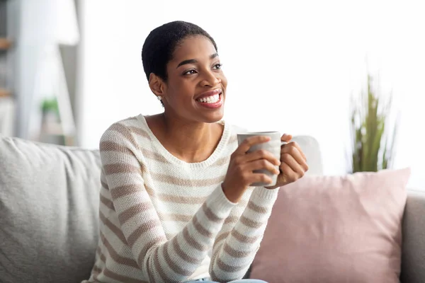Σ / Κ Αναψυχής. Χαρούμενη νεαρή μαύρη νοικοκυρά πίνοντας καφέ στο σπίτι — Φωτογραφία Αρχείου