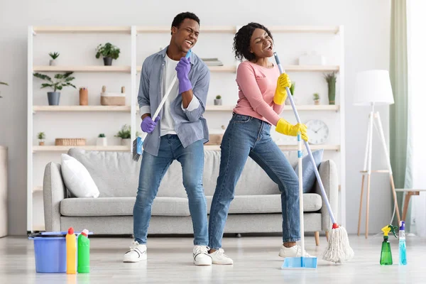 Engraçado família afro-americana se divertindo ao limpar apartamento — Fotografia de Stock