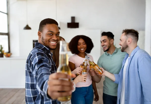 Cool black guy avec bouteille de bière et groupe d'amis multiraciaux disant CHEERS, célébrer quelque chose, faire la fête — Photo