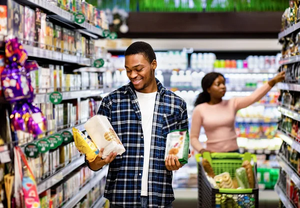 黒人男性と食料品のための彼のガールフレンドのショッピング,モールで健康食品の選択を行います,コピースペース — ストック写真