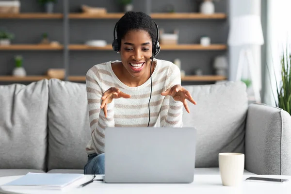 Onlinekonferens. Ung svart dam i headset med webbsamtal på laptop — Stockfoto