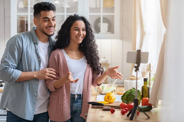 Unga arabiska par som använder smartphone på stativ i köket för inspelning Vlog — Stockfoto