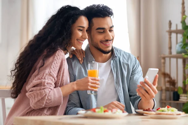 Happy Middle Eastern Couple Browsing Internet On Smartphone While Having Breakfast — Stok Foto