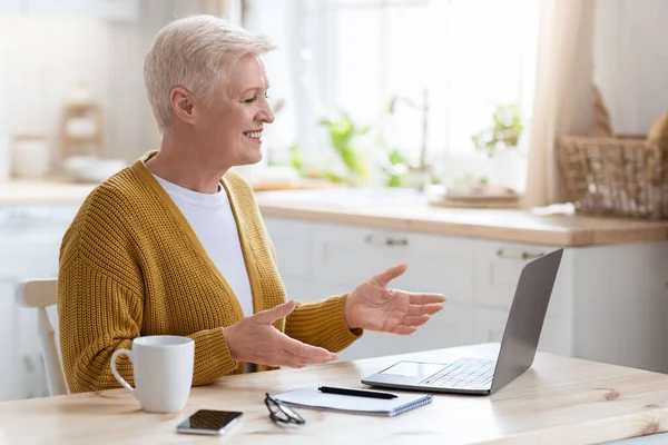Χαρούμενη ηλικιωμένη γυναίκα που κάνει online μαθήματα, μιλάει με τον δάσκαλο — Φωτογραφία Αρχείου