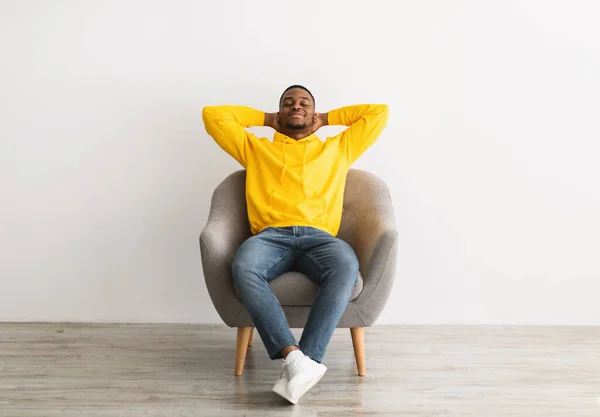 Rahat Siyah Adam Gri Arkaplanda Oturarak Dinleniyor — Stok fotoğraf