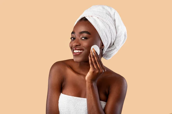 Портрет возбуждённой чёрной женщины, очищающей кожу с помощью ваты — стоковое фото