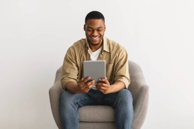 Siyah Adam Tablet Kullanıyor Gri Arkaplanda Sandalyede Oturuyor