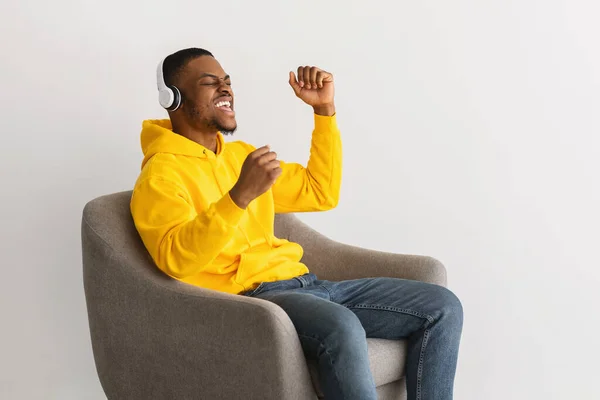 Negro chico usando auriculares escuchar a favorito canción, gris fondo —  Fotos de Stock
