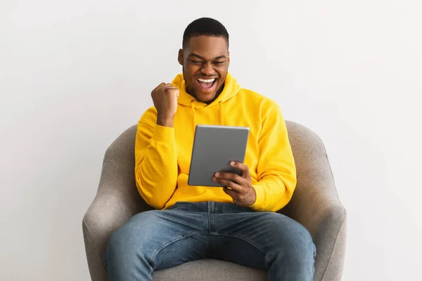 Chico africano alegre usando tableta digital Gestos Sí, fondo gris —  Fotos de Stock