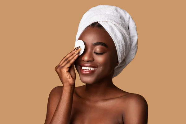 Portrait of excited black woman cleaning skin by cotton pad — Stok Foto