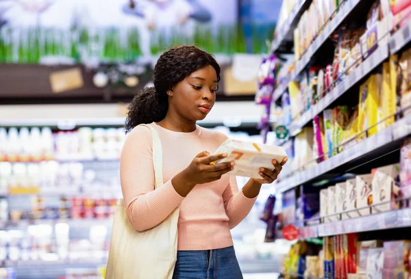 食品を保持トートバッグと魅力的な黒人女性,スーパーマーケットで食料品を購入 — ストック写真