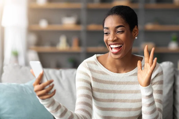 Fröhliche Afroamerikanerin telefoniert zu Hause mit dem Smartphone — Stockfoto